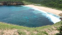 Pantai yang melengkung di lihat dari atas TWA Gunung Tunak