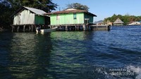 Salah satu pulau kecil di atas Danau Sentani dengan rumah-rumah panggungnya.