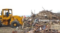Tracktor mengangkut sampah yang semakin menggunung di pantai Kuta