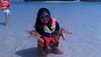 Bermain-main dengan bintang laut di pinggir pantai