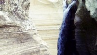 Air terjun yang mengalir ke sela-sela bebatuan