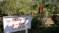 tugu perbatasan mm 13 dengan latar belakang rumah semut raksasa