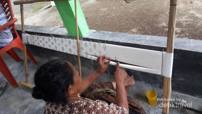 Pengrajin Kota Banjir sedang menenun kain ikat dengan alat tradisional