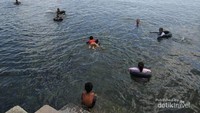 Para pengunjung yang berenang ditepian pantai, tampak menikmati ketengan air laut pagi itu.