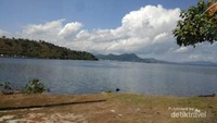 Paduan awan putih, langit biru, dan pulau-pulau serta jajaran bukitnya menambah keindahan.