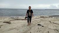Pasir putih dan air hitam Pantai Sei Bakau