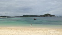 Paduan pasir putih dan biru kehijauan laut yang tenang