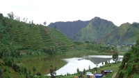 Telaga Cebong diapit ladang serta bukit hijau