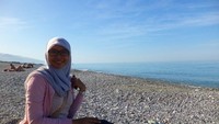 Duduk menikmati matahari dan hamparan laut biru