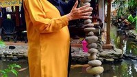 Bisa berpose sambil menyusun batu sungai.