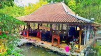 Limasan yang dikelilingi kolam ikan dan terletak di tepi sungai.