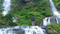 Tampak Curug Sejajar dari dekat, menjulang tinggi mengalirkan air dari atas bukit.