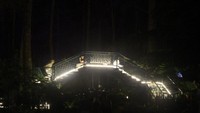 Jembatan kayu saat malam tiba juga dihiasi lampu-lampu.