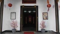 Pintu masuk gedung dengan tulisan candranaya besar di atasnya , dan keterangan gedung di sebelah kiri serta keterangan tentang pemilik di sebelah kanan.