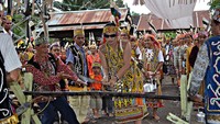 Prosesi memotong kayu sebelum naik ke rumah panjang