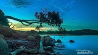 Pemandangan sejauh mata memandang adalah danau yang luas dan tenang, dengan latar perbukitan, warna langitnya juga luar biasa