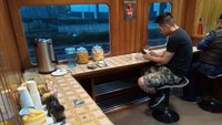 Minibar di bagian belakang tersedia layanan minum swalayan untuk penumpang. Gratis, dan kita juga bisa bekerja di situ jika ada panggilan pekerjaan yang tidak bisa ditunda
