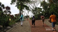 Berjalan-jalan di sekitar lokasi dengan jalan yang rapi dan pepohonan di sekitarnya.