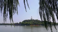 Pagoda berwarna putih di gunung Bunga Giok tampak dari seberang danau