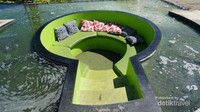 Tempat duduk bernuansa hijau dengan bantal-bantal yang menjadi salah satu spot foto favorit.