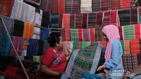 Souvenir yang dijual di Onan Balige tidak hanya berupa sarung tapi ada juga ikat kepala, syal, taplak meja dan hiasan dinding dari Ulos atau tenun khas Batak.