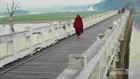 Biksu berjalan di jembatan