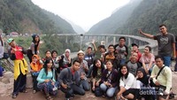 Foto bersama dengan latar Jembatan Kelok Sembilan