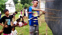 Anak panah yang melesat dan tertahan oleh bidang karpet berbahan karet