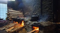 Tungku tanah dengan bahan bakar kayu untuk memasak ayam.