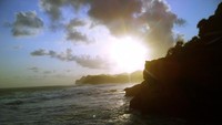 menikmati sunset sambil duduk di batu karang