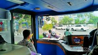 Bus attendant yang bertugas untuk mengatur naik turunnya penumpang dan memberikan informasi tentang destinasi wisata yang dilalui