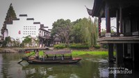 Kapal berlayar dengan background bangunan tradisional cina berdinding putih