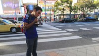 menikmati takoyaki sambil berjalan menyusuri Dotunburi