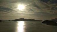Hiasan perbukitan berpadu dengan pulau kecil yang indah saat sunset.
