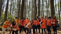 Berfoto dengan latar belakang pohon pinus yang menjulang tinggi