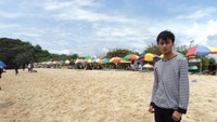 Pose dengan latar payung-payung pantai