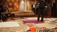 Pemilik showroom menjelaskan seluk beluk karpet handmade.