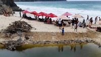 Gundukan sampah dan genangan air kotor di dekat area pantai.