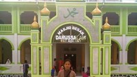 Berfoto di depan masjid.