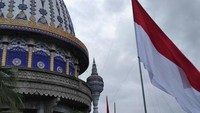 Bendera Merah Putih raksasa yang berkibar bersebelahan dengan salah satu kubah