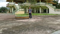 Saya berfoto di depan rumah adat