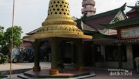 Bagian depan Vihara Lalitavistara dengan latar belakang menara Pagoda bertingkatnya