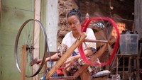 Gulungan benang dipintal agar menjadi helaian sebelum di susun di alat tenun.