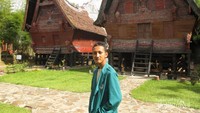 Berfoto di depan rumah adat Batak
