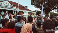 Masyarakat sedang menyaksikan arak-arakan gunungan dan prajurit Keraton