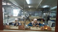 pekerja yang sedang tekun mengolah timah