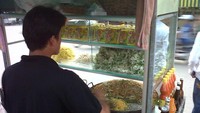 Penjual sedang memasak mie pesanan pembeli.
