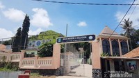 Bukitnya memang tepat berada di belakang sekolah.