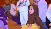 Seorang anak sednag serius mendengarkan cerita