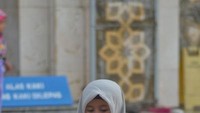 Seorang anak yang sedang bermain dengan kucing sambil menunggu orangtuanya yang sedang mengikuti kajian